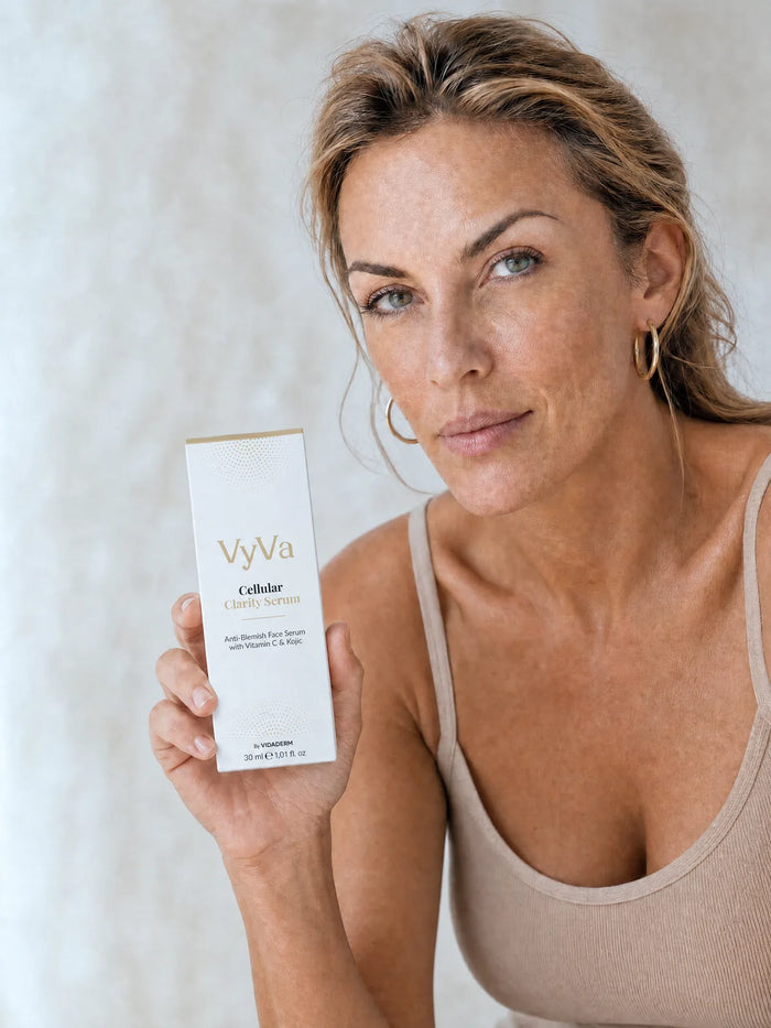 A woman holding the Cellular Clarity Serum carton