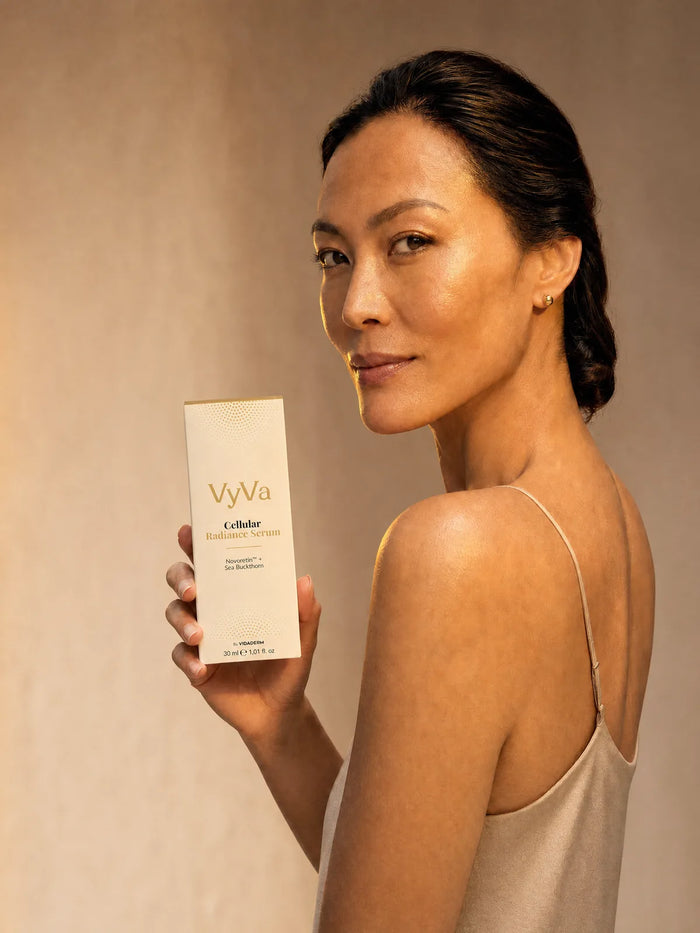 A woman holding the Cellular Radiance Serum carton
